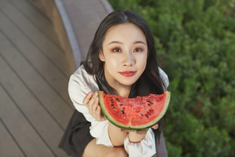 初夏户外公园吃西瓜的可爱少女