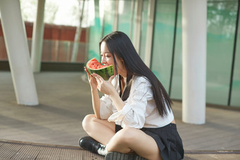 初夏户外公园吃西瓜的可爱少女