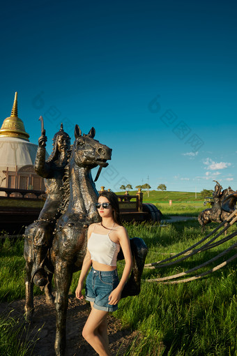 草原湿地公园游玩拍照的亚洲少女