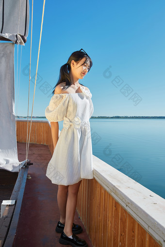 在湖畔木制帆船上的亚洲美女