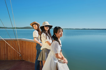 在湖畔木制帆船上的亚洲美女闺蜜