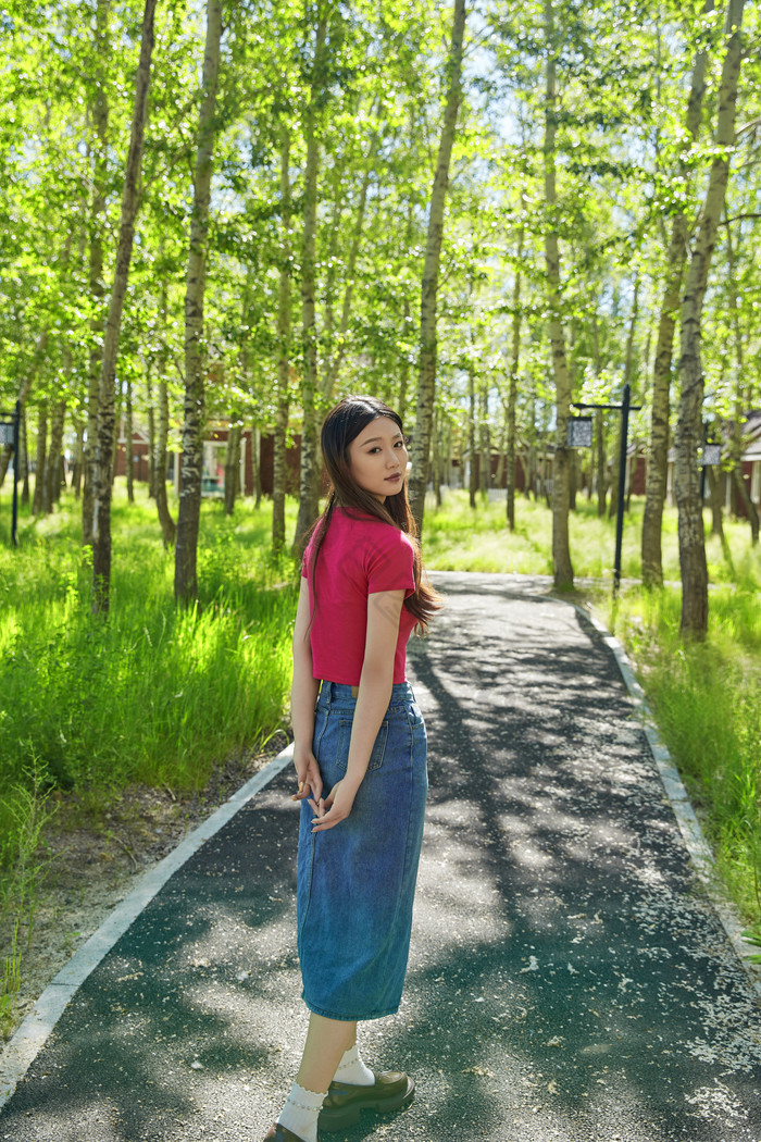 站在绿草如茵的木屋别墅群外的东方美女