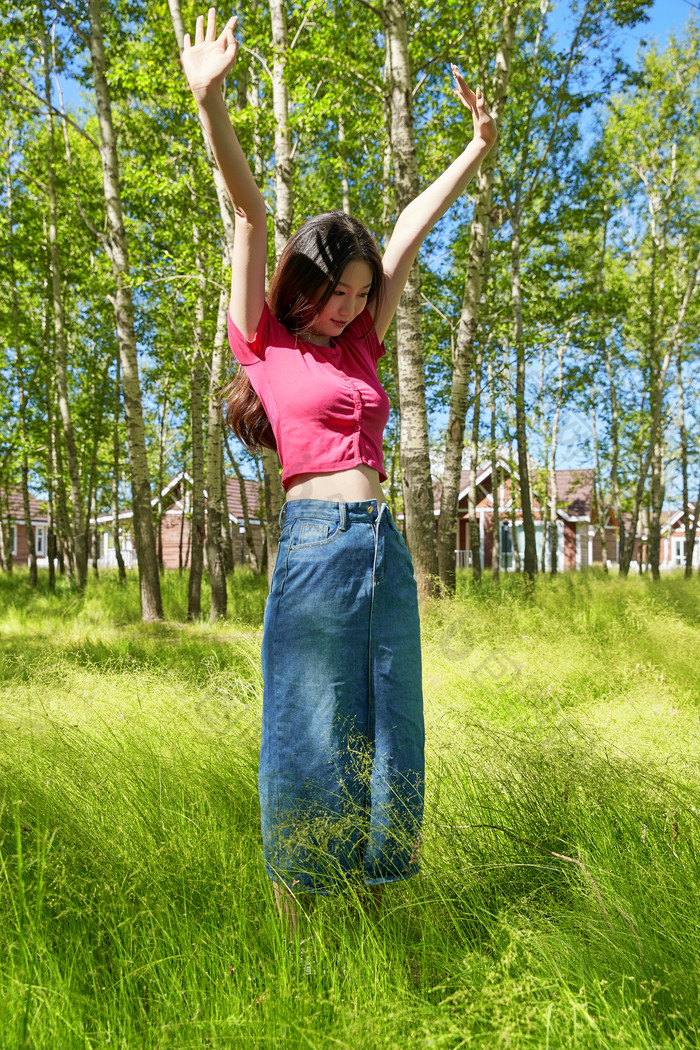 站在绿草如茵的木屋别墅群外的东方美女