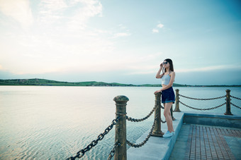 盛夏夕阳晚霞湖边码头看风景的少女