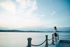 盛夏夕阳晚霞湖边码头看风景的少女