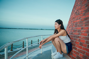 盛夏夕阳晚霞湖边码头看风景的少女