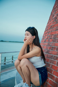 盛夏夕阳晚霞湖边码头看风景的少女