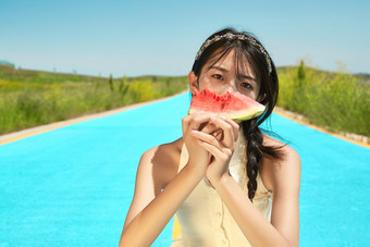 夏日户外湖边彩色公路上玩耍吃西瓜的少女