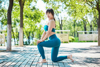 湖畔公园做瑜伽动作的亚洲年轻女性