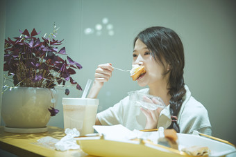 在<strong>烘焙店</strong>吃面包喝牛奶的可爱亚洲少女