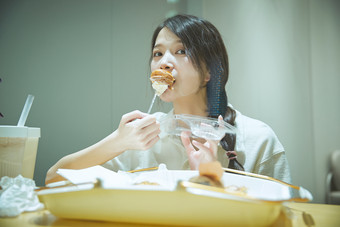 在烘焙店吃面包喝牛奶的可爱亚洲少女