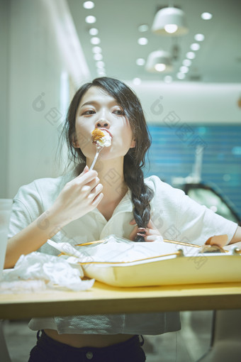 在烘焙店吃面包喝牛奶的可爱亚洲少女