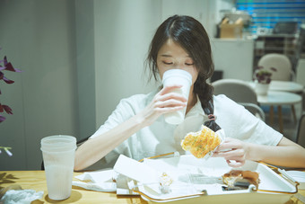在烘焙店吃面包喝牛奶的<strong>可爱</strong>亚洲少女