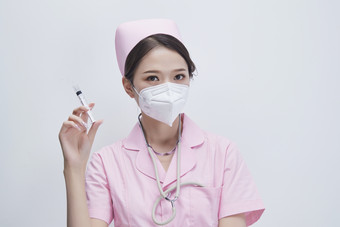 穿护士服戴听诊器口罩手执针筒的年轻女护士图片