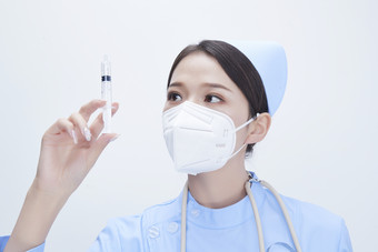 穿护士服戴听诊器口罩和手执针筒的美女护士