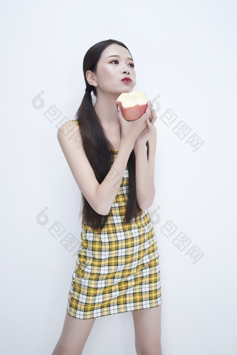 手拿苹果身穿格子吊带裙的亚洲可爱少女人像