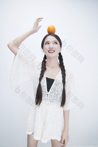 头顶橙子身穿<strong>镂空</strong>连衣裙的亚洲可爱少女人像