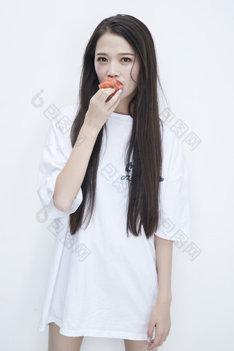 吃番茄的身穿白色长T血衬衫的长发少女人像