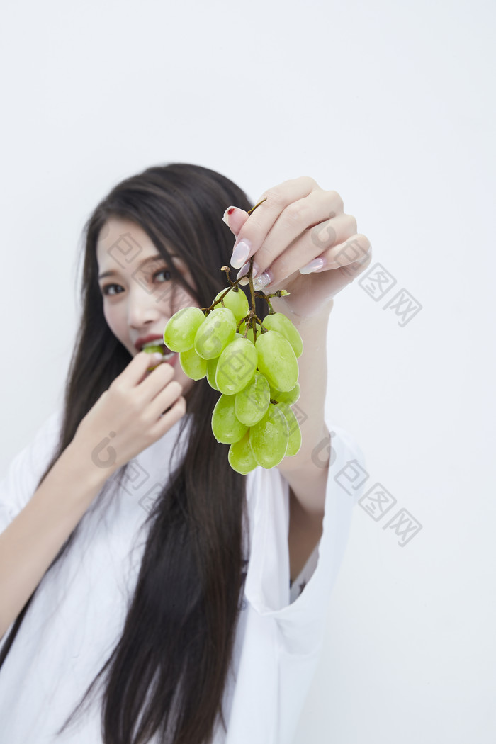 吃葡萄的穿白色长T血衫的长发可爱少女人像