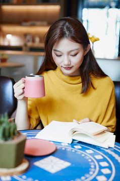 在图书咖啡馆阅读书籍的少女