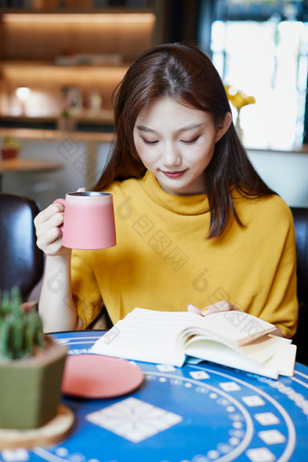 在图书咖啡馆阅读书籍的少女