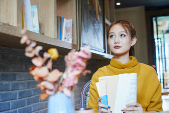 在图书咖啡馆阅<strong>读书籍</strong>的少女