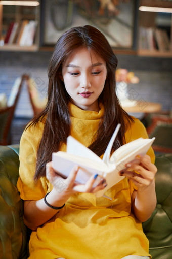 在图书咖啡馆阅<strong>读书籍</strong>的少女