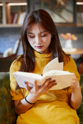 在图书咖啡馆阅<strong>读书籍</strong>的少女
