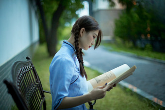 细雨中庭院里竹林前怀抱古书籍的<strong>民国</strong>风少女