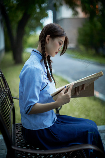 细雨中庭院里竹林前怀抱古书籍的<strong>民国</strong>风少女