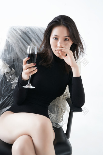坐在椅子上独自品尝<strong>红酒</strong>的亚洲女性