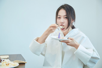 在烘焙店吃蛋糕喝饮料的可爱亚洲少女