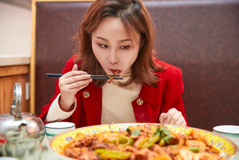 在餐厅吃美味<strong>新疆</strong>大盘鸡的亚洲少女
