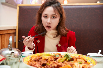 在餐厅吃美味新疆<strong>大盘鸡</strong>的亚洲少女