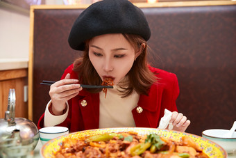 在餐厅吃美味<strong>新疆大盘鸡</strong>的亚洲少女