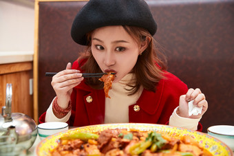 在餐厅吃美味新疆<strong>大盘鸡</strong>的亚洲少女