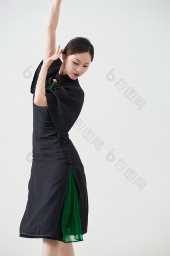 穿着黑色旗袍翩翩舞蹈的亚洲少女舞者