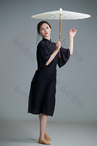 穿中式旗袍手拿油纸伞翩翩舞蹈<strong>的</strong>亚洲少女舞者