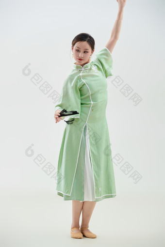 穿着中式旗袍翩翩舞蹈的亚洲少女舞者