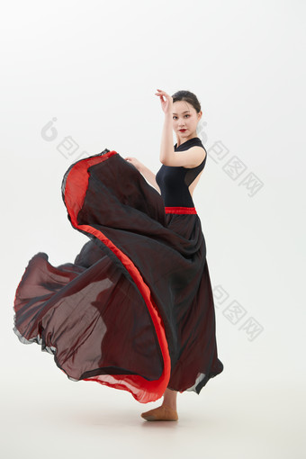 身穿红黑相间的舞蹈长裙翩翩起舞的少女
