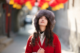 春节在老城古巷穿着喜庆服饰的美丽少女