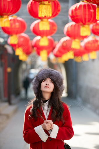 春节在老城古巷穿着喜庆服饰的美丽少女