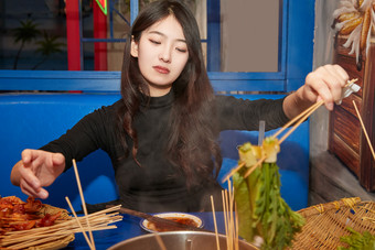 在饭馆吃成都串串的亚洲少女