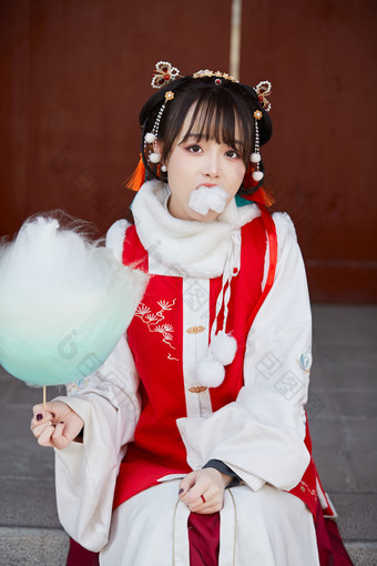 身穿喜庆汉服吃棉花糖的少女