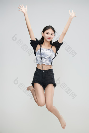 白色背景下腾空跳跃的可爱亚洲少女