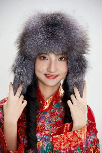 白色背景下穿中国传统<strong>服</strong>饰头戴绒帽的少女