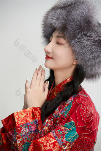 白色背景下穿中国<strong>传统服饰</strong>头戴绒帽的少女