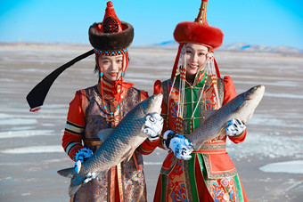 穿着蒙族服饰参加冬季捕鱼活动的闺蜜少女
