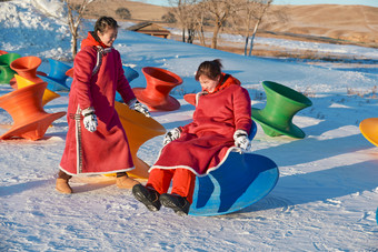 在冰天雪地玩耍雪上娱乐载具车辆的<strong>闺蜜</strong>少女
