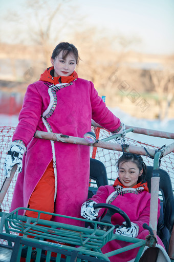 在冰天雪地玩耍雪上娱乐载具车辆的闺蜜少女